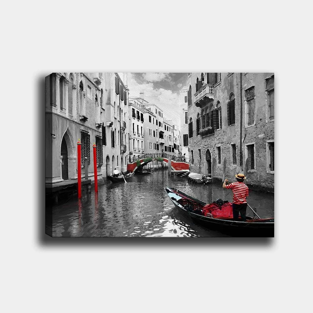 Lerretsbilde 70x100 cm - Gondolier som navigerer gjennom en venetiansk kanal med fargerike detaljer i et svart-hvitt miljø v:5001575